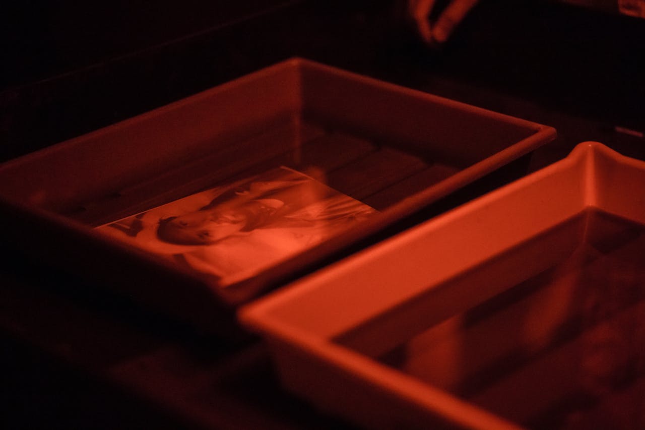 creative-03 Capturing the classic film development process in a darkroom with trays and red light.
