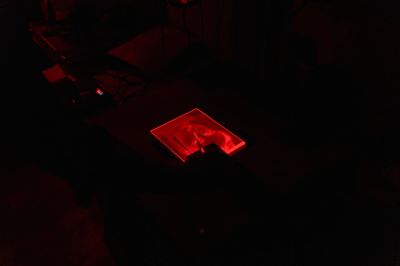 why-choose-us Capturing the essence of traditional photo development in a darkroom with a striking red light hue.